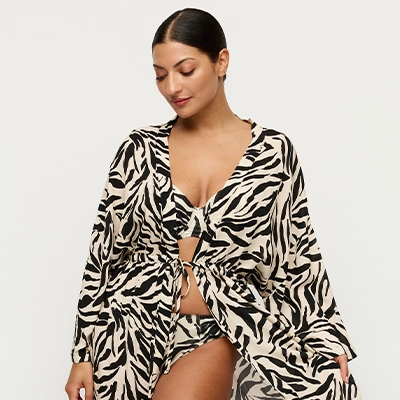 a woman wearing a zebra print bathing suit coverup